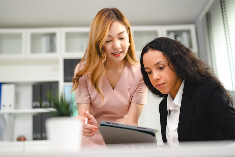 2 women discussing paid advertising services on a computer